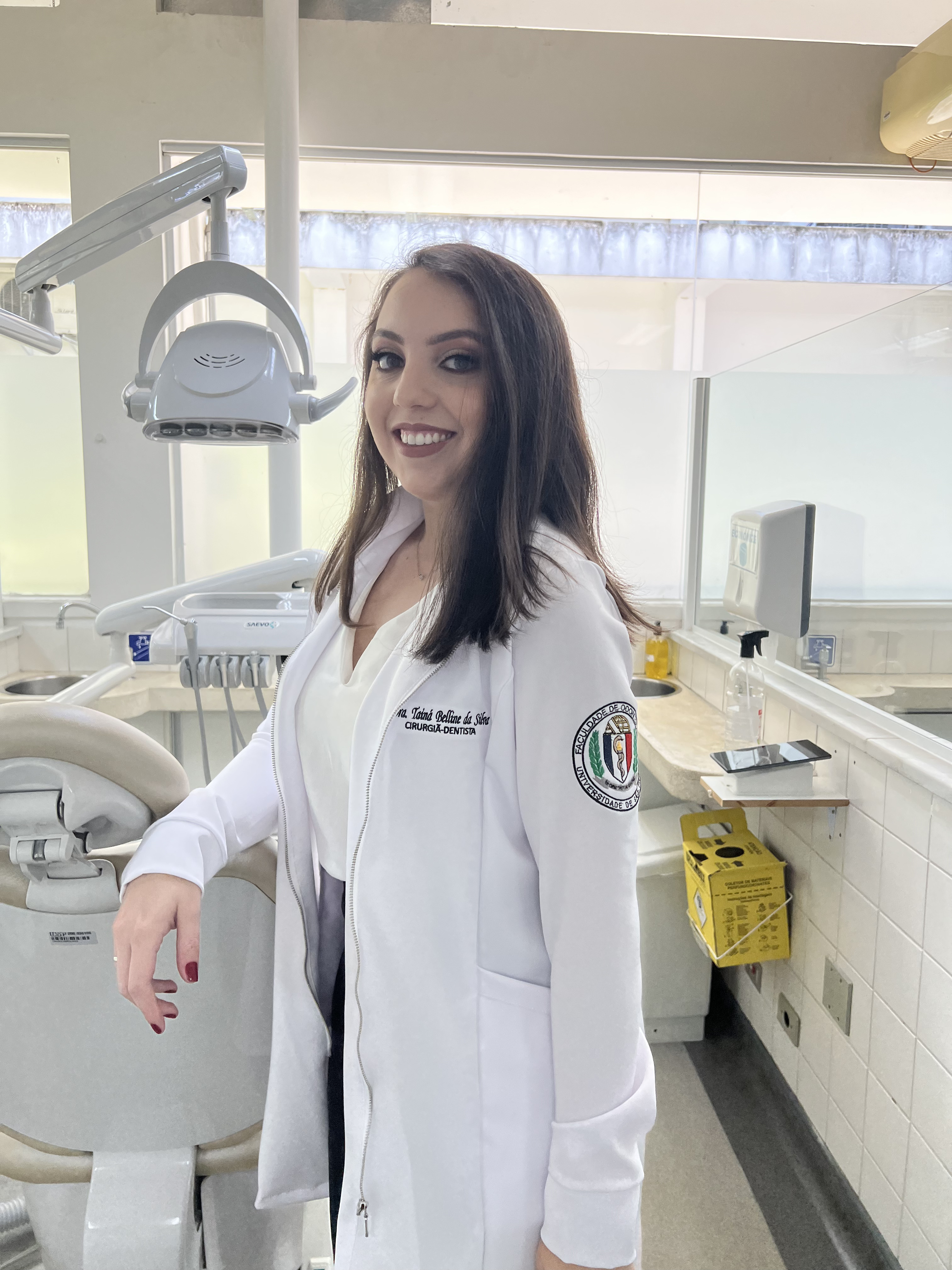 Dra. Tainá Belline no consultório com paciente